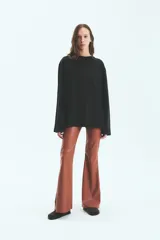 Pantalón de tiro alto confeccionado en ecocuero con textura de efecto croco. Presenta un corte semi oxford con un recorte horizontal sobre la rodilla y cierre invisible en el lateral.