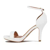 Sandalia de tacón alto negra, con plataforma delantera y una tira ancha sobre los dedos. Posee una tira fina alrededor del tobillo con hebilla metálica dorada para ajuste.