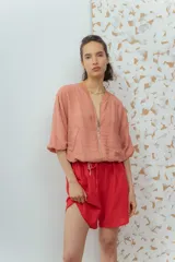 Short blanco de calce relajado con cintura elástica y lazo regulable. Presenta bolsillos amplios con ribete interior de color naranja neón.