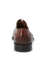 Zapato de vestir tipo Oxford en cuero color marrón, con puntera reforzada y cierre mediante cordones. Presenta un diseño clásico con suela mixta de cuero y goma.