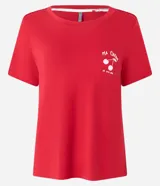 Blusa de pijama de manga corta en color rojo, confeccionada en viscosa con elastano. Presenta un pequeño estampado de cerezas y texto en el pecho.