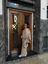 Pantalón de lanilla color beige, de corte recto y tiro alto, con diseño holgado y fluido.