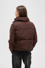Campera híbrida con cuerpo delantero acolchado tipo puffer y mangas de tejido de punto acanalado con cuello alto. Presenta un diseño corto y holgado con cierre frontal oculto.