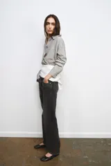 Jeans de tiro medio y corte recto, confeccionados en algodón con efecto lavado en tono gris oscuro. Presentan cintura con trabillas, cierre frontal con cremallera y botón, y diseño clásico de cinco bolsillos.