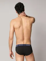 Pack de tres slips Calvin Klein de color negro, confeccionados en mezcla de algodón y elastano. Cuentan con talle medio y una distintiva cintura elástica con logo de la marca en colores azul marino, blanco y verde.