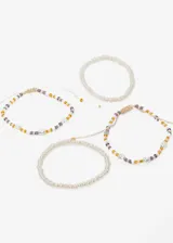Set de cuatro pulseras elásticas con cuentas de perlas sintéticas y mostacillas de colores.
