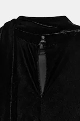 Vestido midi de terciopelo negro con cuello redondo y pañuelo integrado en el mismo tejido. Presenta mangas cortas, aberturas laterales con detalle de encaje a tono y bajo asimétrico con terminación en encaje.