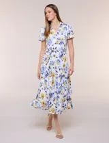 Vestido midi de seda fría blanca con estampado floral en tonos azules y amarillos, escote en V con cuello solapa, mangas cortas, lazo ajustable en la cintura y falda plisada.