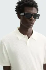 Polo de punto canalé color rosado, de corte regular fit, con cuello solapa y cierre frontal de botonadura. Manga corta y acabados en rib.