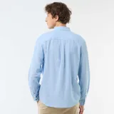 Camisa de manga larga en color azul cielo, confeccionada en mezcla de lino con botones frontales imitación madera y cuello con botones.
