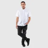 Camisa de manga corta con cuello clásico, cierre frontal de botones y un bolsillo en el pecho. Presenta un diseño de corte regular con textura natural.