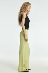 Pantalón de tiro medio confeccionado en mezcla de lino, con cintura ajustable mediante lazada, trabillas, bolsillos laterales y cierre frontal con cremallera y botón.