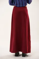 Falda larga color borgoña, confeccionada en tela suave con acabado tipo piel de durazno y cierre invisible lateral.