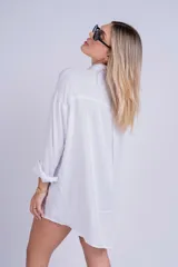 Camisa negra de corte oversize y estilo casual, confeccionada en tela liviana, con mangas largas, cuello camisero y cierre frontal con botones.