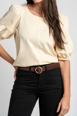Remera de algodón negro con mangas cortas abullonadas, cuello redondo y costura central frontal.