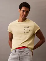 Remera color crema de algodón con cuello redondo y mangas cortas con dobladillo. Estampado vertical con el logo de Calvin Klein Jeans en el frente.