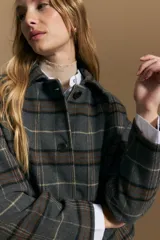 Tapado corto de lana con diseño a cuadros en tonos azul y negro, cuello camisero y cierre frontal con botones.
