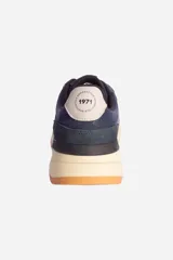 Zapatillas urbanas de hombre, color azul marino, con detalles en blanco y suela color caramelo.