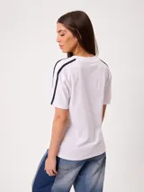 Remera blanca con estampado frontal de la marca Rusty y tiras laterales en las mangas, de ajuste holgado y 100% algodón.
