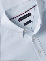 Chomba celeste de piqué con textura tipo diamante, cuello tipo chomba, tapeta de cinco botones y logo de Tommy Hilfiger bordado en el pecho.