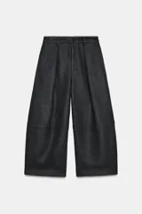 Pantalón de tiro medio con diseño balloon de pierna ancha. Presenta pliegues frontales, costuras horizontales marcadas en las piernas, bolsillos laterales y cierre frontal con cremallera y botón.