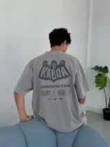Remera oversize gris con efecto acid wash y estampa frontal con la leyenda "WORLDWIDE TOUR" en tipografía gótica.