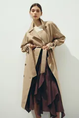 Gabardina midi de doble botonadura con diseño oversized, solapas de muesca, cierre frontal con botones y cinturón extraíble para atar en la cintura. Presenta mangas raglán con trabillas ajustables en los puños, bolsillos laterales y abertura posterior.