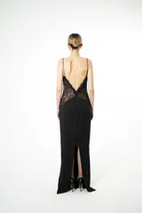 Vestido largo negro de silueta fluida con delicado encaje floral y transparencias estratégicas en el torso. Escote profundo con breteles finos.