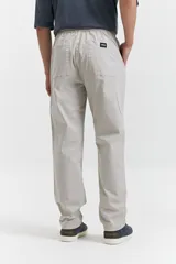 Pantalón de gabardina color azul marino, con diseño de cinco bolsillos, corte relajado, cintura elastizada con cordones ajustables y terminación recta sin puños.