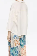 Camisa corta de lino con estampado de animales, corte boxy, cuello camisero, manga 3/4 con sisa ajustable y tiras de tejido.