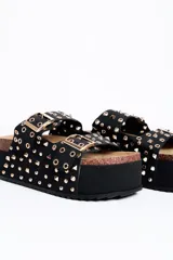Sandalia plataforma color negro, con doble tira ancha con hebillas y tachas doradas, suela de corcho y plataforma alta texturizada.
