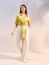 Camisa de textura arrugada en color verde lima, con cuello clásico, mangas cortas y diseño frontal anudado en la cintura.