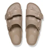 Sandalias Birkenstock modelo Arizona, fabricadas en material EVA ligero y flexible, color taupe. Presentan diseño de dos correas ajustables con hebillas del mismo tono y plantilla anatómica.