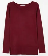 Suéter de punto color rosado, con cuello barco, mangas largas y puños con botones decorativos. El dobladillo también es acanalado.