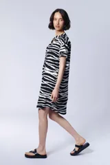 Vestido camisero corto con estampado de cebra en blanco y negro, cuello mao y mangas cortas.