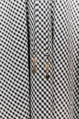 Falda midi de tiro medio con estampado de cuadros vichy en blanco y negro. Presenta cintura elástica con cordón ajustable y caída fluida.