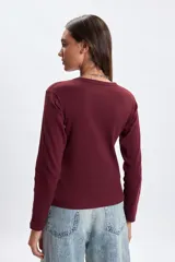 Remera de manga larga confeccionada en tejido rib, con cuello redondo y ajuste al cuerpo.