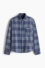 Camisa de sarga de algodón con diseño a cuadros, cuello inglés, bolsillo superior y mangas largas con puños abotonados.