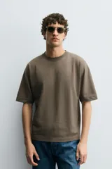 Camiseta de corte relajado confeccionada en algodón compacto, con cuello redondo y mangas cortas sin costura de sisa.