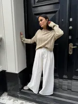 Sweater color crema tejido con diseño en ochos y cuello redondo.