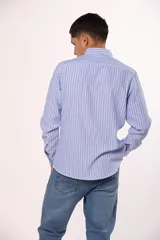 Camisa de manga larga con estampado de rayas verticales, cuello abotonado y cierre frontal con botones.