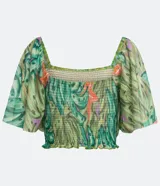 Blusa cropped de tul con estampado de bananas, escote cuadrado, mangas cortas amplias, detalle de látex en el cuerpo y volantes en el bajo.