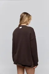 Sweater de punto marrón de tejido liviano y calce relajado, con hombros caídos, cuello redondo y puños y cintura en rib. Cuenta con una estampa tejida en el frente con la frase "Estoy Blessed" en color amarillo.