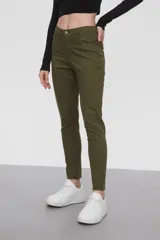 Pantalon de jean negro, corte skinny y tiro medio, con cierre frontal y bolsillos laterales.