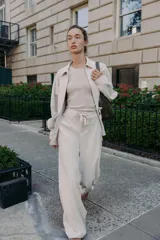 Pantalón blanco de tiro alto con pierna ancha y cordón ajustable en la cintura. Presenta bolsillos laterales y falsos bolsillos de vivo en la parte trasera.