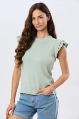 Remera tejida de algodón en color beige, de cuello redondo, sin mangas y con detalles de volados estructurados en los hombros.