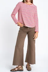 Remera de manga larga con diseño de rayas horizontales en blanco y negro, cuello redondo y corte ajustado al cuerpo.