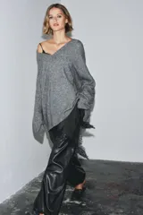 Jersey oversize color beige melange, confeccionado con lana, con cuello en V y manga larga.