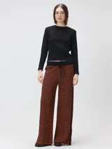 Pantalón de tejido jacquard con textura geométrica en tonos tostado y beige, de tiro medio, cintura elástica con cordón de ajuste y pierna ancha.