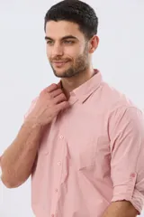 Camisa celeste de manga larga confeccionada en algodón, con cuello camisero, cierre frontal de botones, bolsillo en el pecho y diseño de cuadros sutiles.